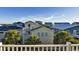 Charming neighborhood scene of colorful beach houses and lush palm trees under a clear sky at 253 W Second Ave. S, Ocean Isle Beach, NC 28469