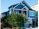 Attractive home with a front porch, white railings, and neatly landscaped yard, perfect for coastal living at 253 W Second Ave. S, Ocean Isle Beach, NC 28469