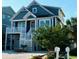 Inviting home exterior with elevated deck, white railings, and landscaped yard near the beach at 253 W Second Ave. S, Ocean Isle Beach, NC 28469