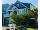 Charming coastal home with blue siding, white trim, and a well-manicured lawn, showcasing curb appeal at 253 W Second Ave. S, Ocean Isle Beach, NC 28469