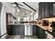 Open-concept kitchen featuring dark cabinets, stainless steel appliances, and a large island with pendant lights at 253 W Second Ave. S, Ocean Isle Beach, NC 28469