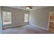 Sunlit bedroom featuring neutral tones, carpet flooring, and two windows overlooking backyard at 681 Hawthorn Dr., Pawleys Island, SC 29585
