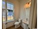 Modern half-bathroom features a stylish vanity, fixtures and natural light from the window at 718 Macon Alley, Myrtle Beach, SC 29588