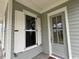 Inviting front porch featuring a gray front door and white trim windows at 718 Macon Alley, Myrtle Beach, SC 29588
