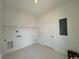 Well-lit laundry room with tile flooring, utility hookups, and access door, practical and functional at 718 Macon Alley, Myrtle Beach, SC 29588