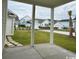 Covered patio featuring a view of the well-manicured lawn and adjacent homes at 718 Macon Alley, Myrtle Beach, SC 29588