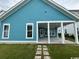 Back exterior featuring a covered patio, blue siding, and well-maintained grass at 734 Macon Alley, Myrtle Beach, SC 29588