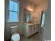 Bright bathroom with a white vanity, modern fixtures, toilet, and a large window at 734 Macon Alley, Myrtle Beach, SC 29588