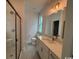 A bright bathroom with a double vanity and glass shower, and a window at 734 Macon Alley, Myrtle Beach, SC 29588