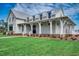 Attractive home with white siding, a metal roof, front yard, and a covered porch with white pillars at 734 Macon Alley, Myrtle Beach, SC 29588