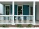Cozy front porch with white railings, comfortable seating, and a charming blue front door at 734 Macon Alley, Myrtle Beach, SC 29588