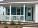 Inviting front porch with white pillars, comfortable seating, and a vibrant blue exterior at 734 Macon Alley, Myrtle Beach, SC 29588