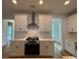 Modern kitchen featuring white cabinets, stainless steel range hood, and a sleek cooktop at 734 Macon Alley, Myrtle Beach, SC 29588