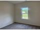 A sunlit bedroom with neutral carpet and a view of the outdoors at 323 Palmetto Sand Loop, Conway, SC 29527