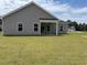 Rear view of the house with a covered patio and a large lawn at 323 Palmetto Sand Loop, Conway, SC 29527