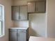 This kitchen features gray cabinets, white countertops, and a white backsplash for a clean and modern look at 323 Palmetto Sand Loop, Conway, SC 29527