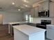 A stylish kitchen featuring gray cabinetry, stainless steel appliances, and a spacious island at 323 Palmetto Sand Loop, Conway, SC 29527