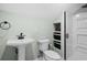 Well-lit bathroom features a pedestal sink, toilet, built-in shelving and stand-up shower with glass door at 5012 Lindrick Ct., Myrtle Beach, SC 29579