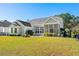 Backyard with a fountain and a lush green lawn; the home has a screened-in porch at 5012 Lindrick Ct., Myrtle Beach, SC 29579