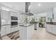 Bright kitchen featuring an island cooktop, stainless appliances, white cabinetry and large windows at 5012 Lindrick Ct., Myrtle Beach, SC 29579