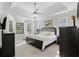 Spacious primary bedroom features a tray ceiling, a ceiling fan, neutral carpet, and a bay window at 5012 Lindrick Ct., Myrtle Beach, SC 29579