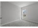 A simple bedroom with soft gray carpeting and a bright window, offering a cozy and comfortable space at 2412 Campton Loop, Conway, SC 29527