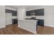 Modern kitchen with blue cabinets, quartz countertop island, stainless steel appliances, and hardwood flooring at 2412 Campton Loop, Conway, SC 29527