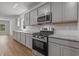 Kitchen features stainless steel oven and microwave, granite counters and gray shaker cabinets at 2441 Campton Loop, Conway, SC 29527