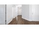 Bright hallway showcasing hardwood floors, white trim, and doorways to adjacent rooms at 2472 Campton Loop, Conway, SC 29527