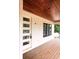Inviting porch with a wood ceiling and deck, modern front door, and large windows, perfect for outdoor living and relaxation at 314 Hollywood Dr. S, Surfside Beach, SC 29575