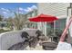 Cozy patio with comfortable seating, a bright red umbrella, and a privacy wall, perfect for outdoor relaxation at 86 Shadow Moss Pl. # 86, North Myrtle Beach, SC 29582