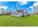 Side view of a well-maintained home with a spacious lawn and exterior staircase at 865 River Rd., Tabor City, NC 28463
