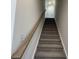 Carpeted staircase with white walls and a wood handrail at 1038 Jase Dr., Longs, SC 29568