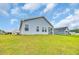 View of the backyard showing manicured lawn and home's light blue siding at 1044 Jase Dr., Longs, SC 29568
