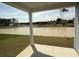 View of a pond and backyard from the covered porch, featuring a column and green grass at 1044 Jase Dr., Longs, SC 29568