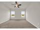 A spacious bedroom featuring carpet flooring, two windows, and a ceiling fan at 1044 Jase Dr., Longs, SC 29568