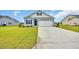 Charming exterior of a light blue home featuring a two-car garage, black shutters, and a manicured lawn at 1044 Jase Dr., Longs, SC 29568