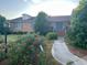 Charming brick home with blooming roses, lush greenery, and a welcoming blue double door at 1692 S Morgan Ave., Andrews, SC 29510