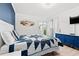 Comfortable bedroom with a blue and white quilt, dresser, and access to a balcony at 191 Maison Dr. # B203, Myrtle Beach, SC 29572