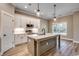 Inviting kitchen boasts an island, white cabinets, stainless appliances, and modern pendant lights at 217 Shady Pines Ct., Conway, SC 29527