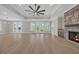 Bright, open-concept living space with wood floors, fireplace, fan, and backyard views at 2515 Saint Andrews Dr., Little River, SC 29566