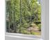 Scenic view of a lush green forest through a bright, white-trimmed window at 2515 Saint Andrews Dr., Little River, SC 29566