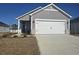 Gray house with white garage door and landscaping at 835 Cypress Preserve Circle, Longs, SC 29568