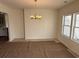 Open dining area with chandelier and bright windows. Flooring protected with paper at 1009 Jase Dr., Longs, SC 29568