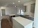 Open-concept kitchen with a central island, gray cabinets, and white countertops. Flooring protected with paper at 1009 Jase Dr., Longs, SC 29568