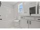 Well-lit bathroom with white cabinets, matching shower and tub, and window view at 1101 Anne St., North Myrtle Beach, SC 29582