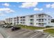 Wide angle view of the condo complex with ample parking and well-maintained landscaping under a partly cloudy sky at 191 Maison Dr. # B320, Myrtle Beach, SC 29572