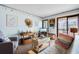 Relaxing living room with a futon, accent chairs, and beach-themed art, opening to the outdoor balcony at 191 Maison Dr. # B320, Myrtle Beach, SC 29572