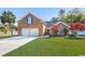 Charming brick home featuring an attached two-car garage, a well-manicured lawn, and an adjacent pond at 305 Duel Ct., Myrtle Beach, SC 29588