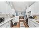 Modern kitchen featuring white cabinets, quartz countertops, and stainless steel appliances, seamlessly connected to the dining area at 305 Duel Ct., Myrtle Beach, SC 29588
